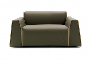 Contemporary low back armchair or snuggle chair with wide seat and wedge arms