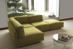 Dennis corner sofa composed of a corner element, two single elements, and an ottoman with casters.