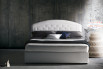 Upholstered bed with rounded tufted headboard
